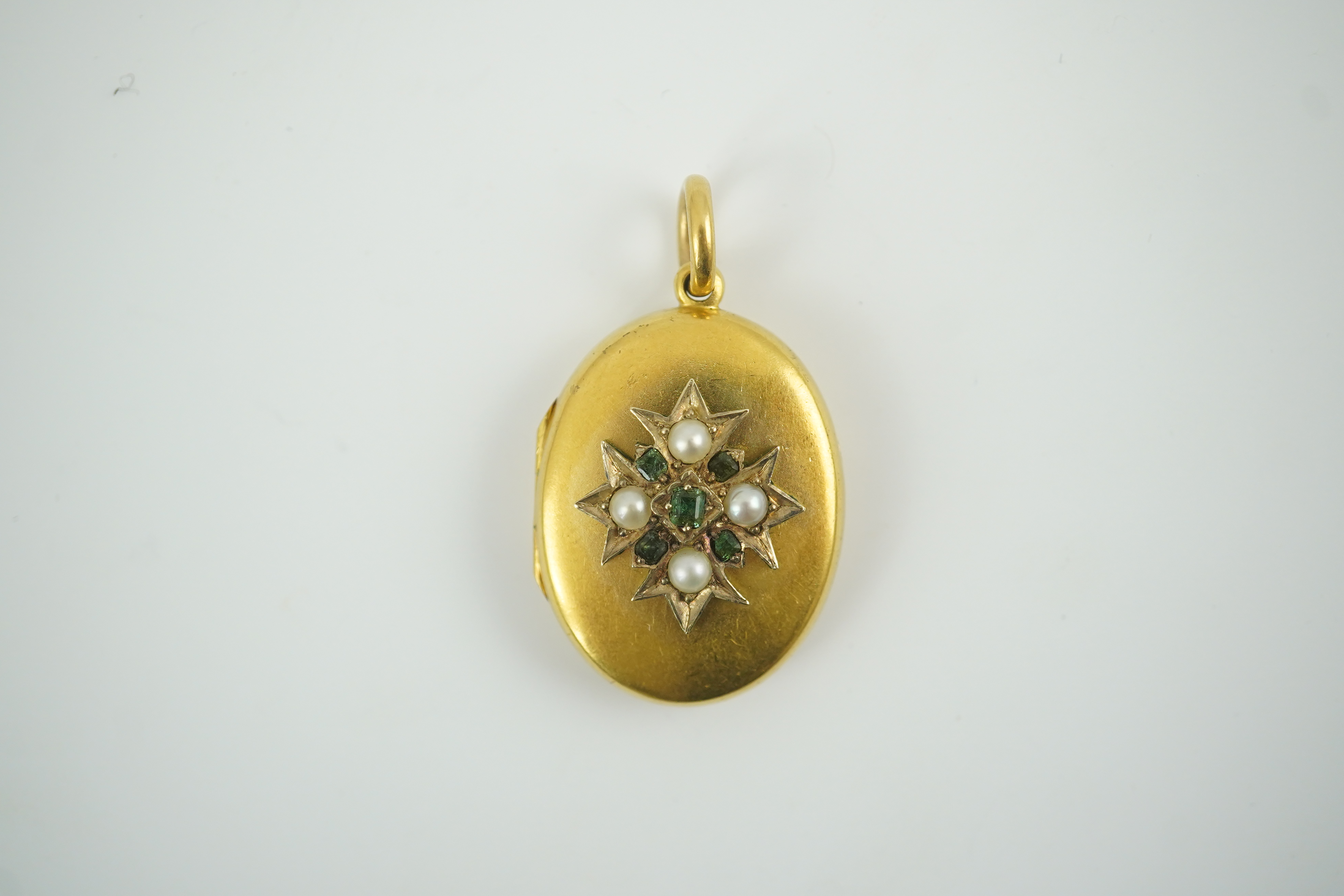 A Victorian gold, split pearl and emerald cluster set oval locket